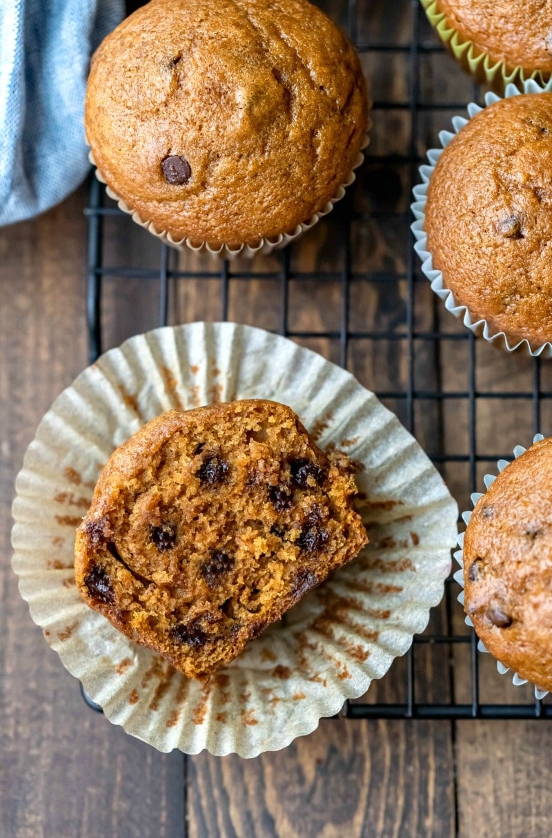 Half of a pumpkin chocolate chip muffin on a wire cooling rack