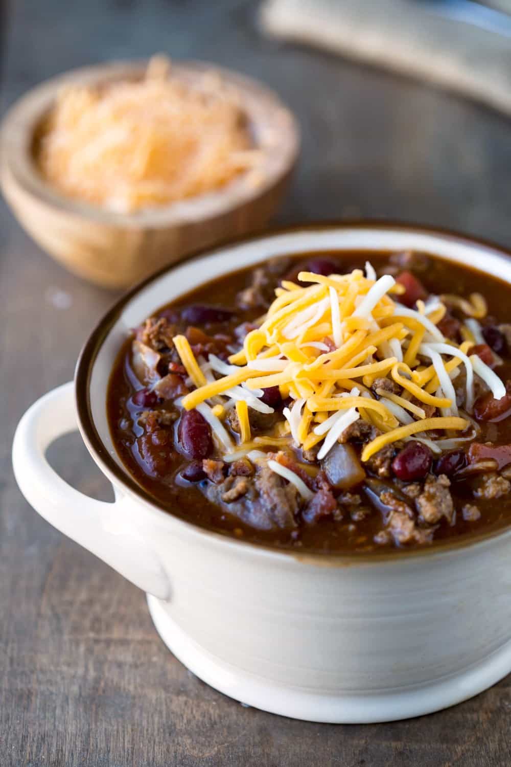 Barbecue Bacon Cheeseburger Chili in a cream bowl with cheese on top
