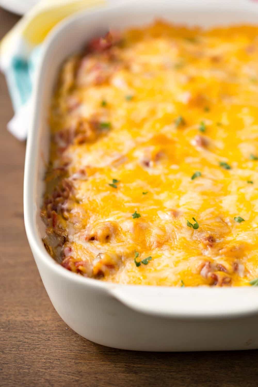 Overnight Mexican Breakfast Casserole in a white baking dish on a wooden background