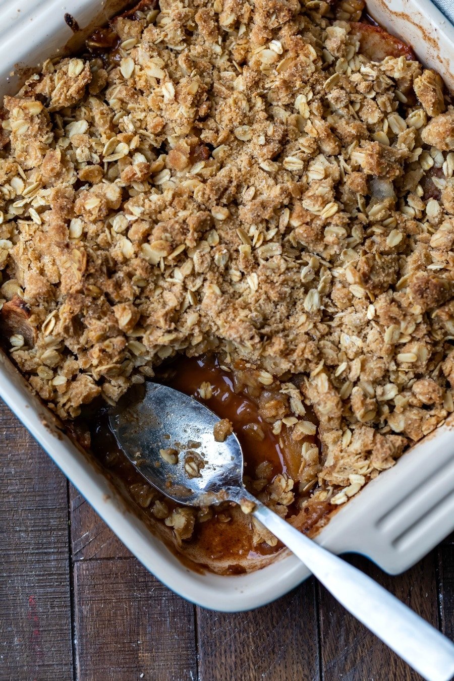 Overhead picture of pan of apple crisp with a scoop missing