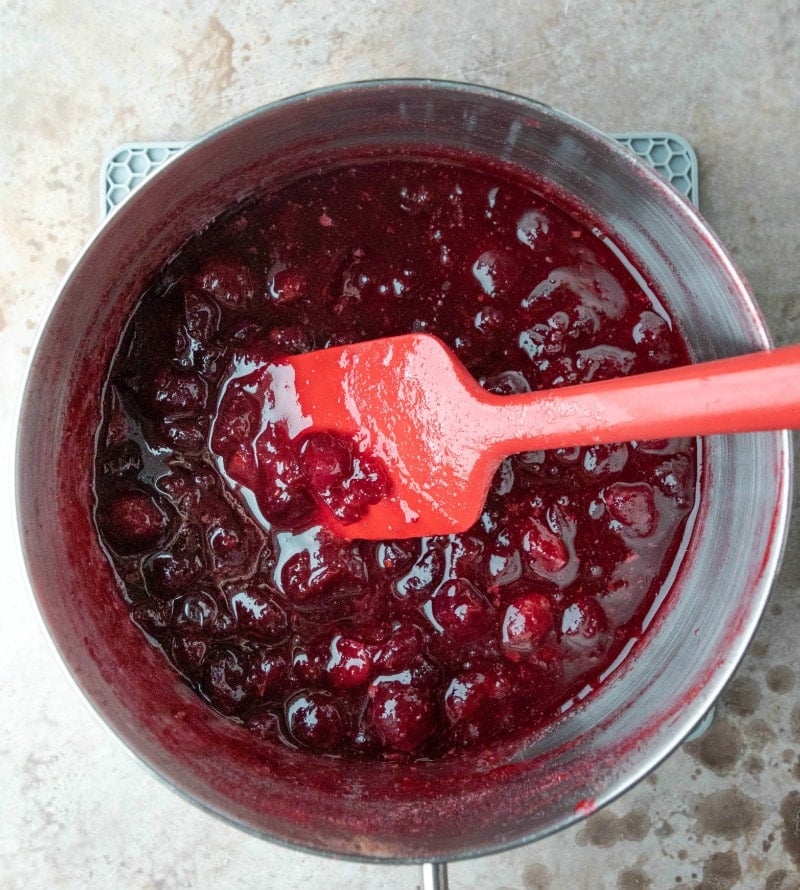 Silver saucepan with cooked cranberry sauce in it