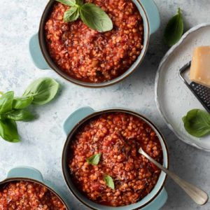 Overhead picture of lentil bolognese in three blue bowls