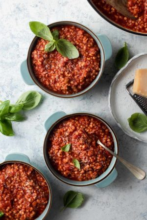 Overhead picture of lentil bolognese in three blue bowls