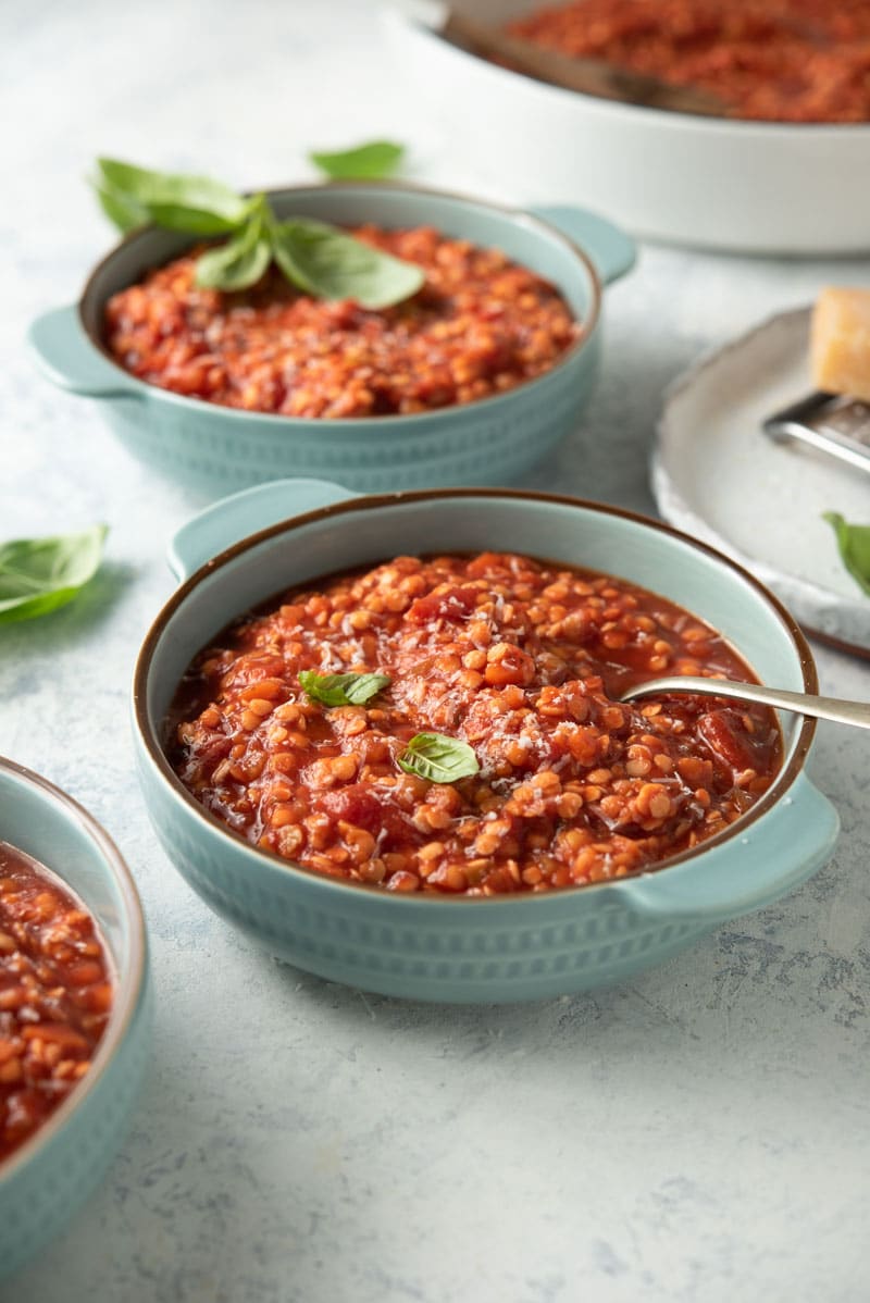 Blue dish with lentil bolognese and fresh basil