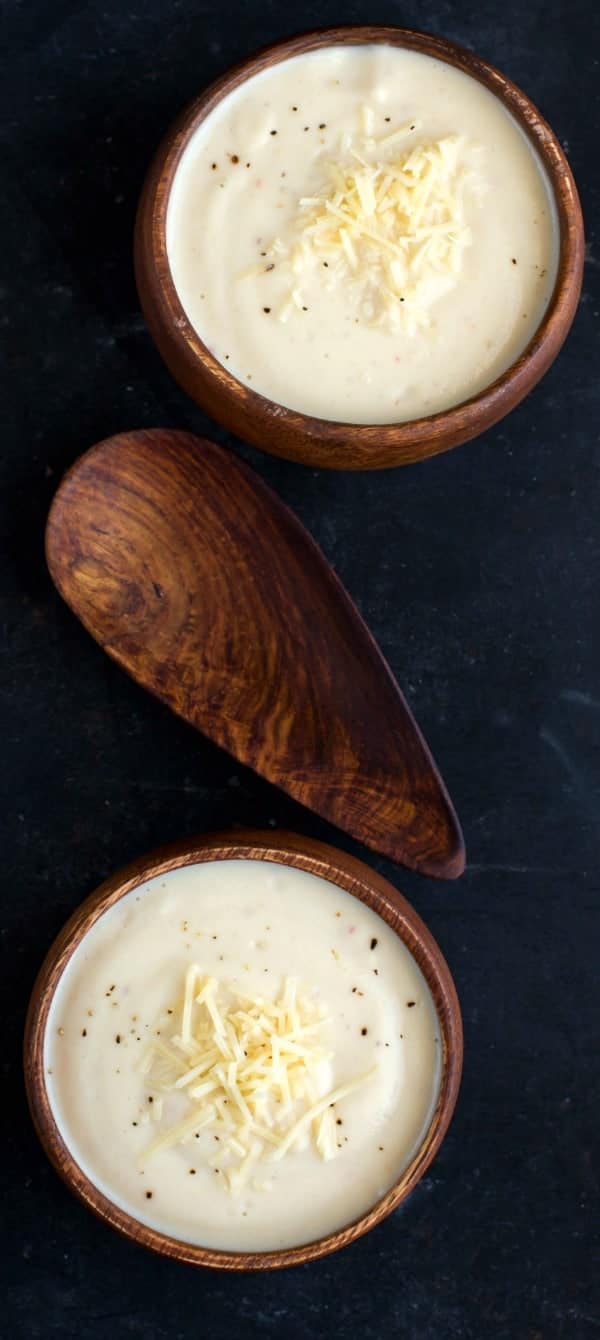 Wisconsin Cauliflower Soup in a wooden bowl topped with pepper and cheese