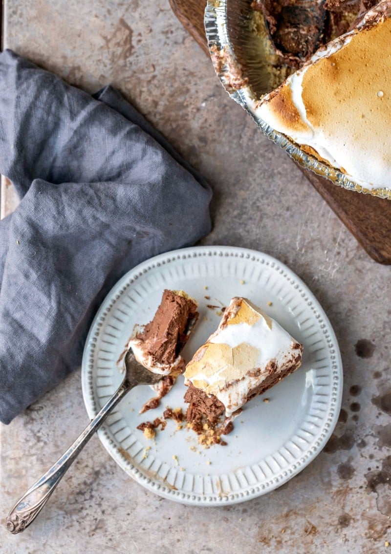 Slice of s'mores pie next to a fork with a bite of pie