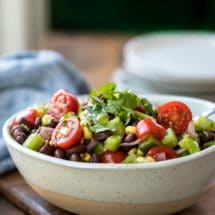 Speckled cream bowl full of black bean salad