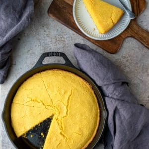 Cast iron skillet of cornbread with one slice missing
