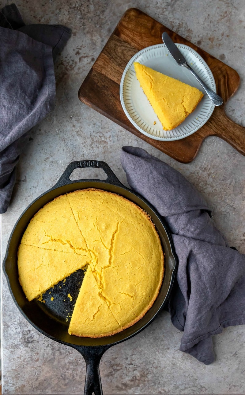 Cast iron skillet of cornbread with one slice missing