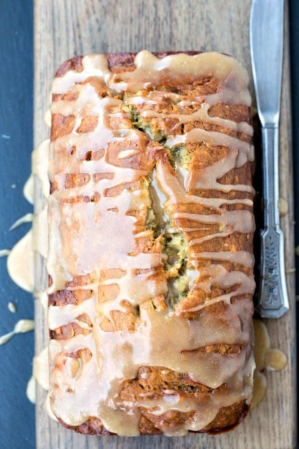 Browned Butter Banana Bread on a wooden cutting board next to a butter knife