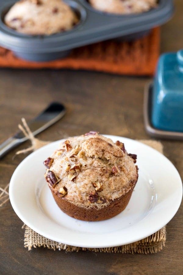 Cream Cheese Banana Muffin on a white plate next to a butter knife and butter dish