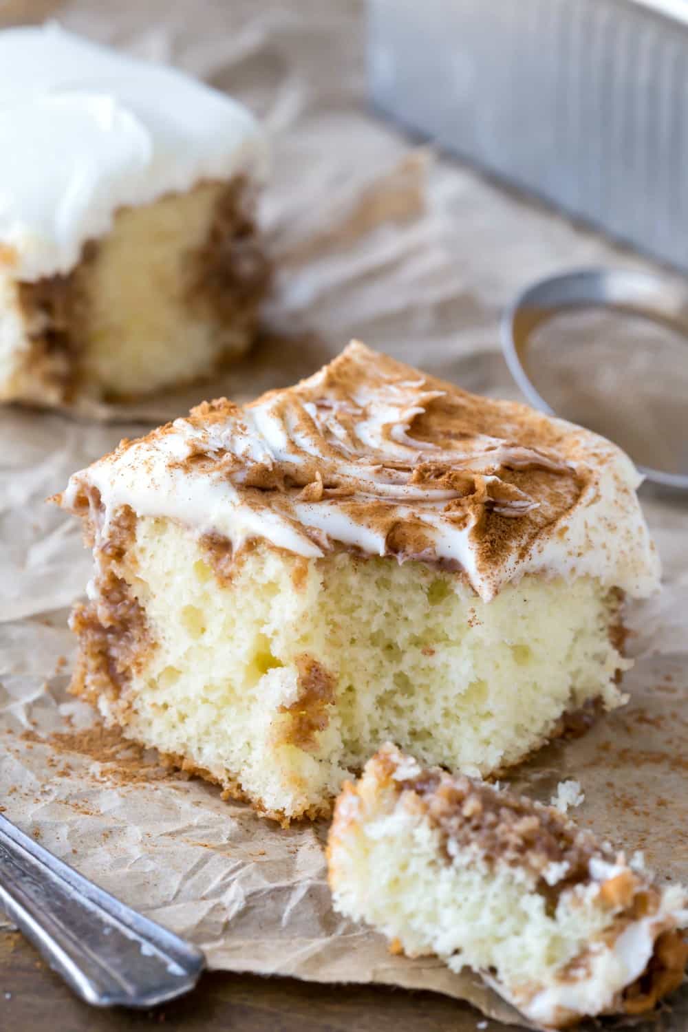 Cinnamon Roll Poke Cake on a piece of brown parchment paper