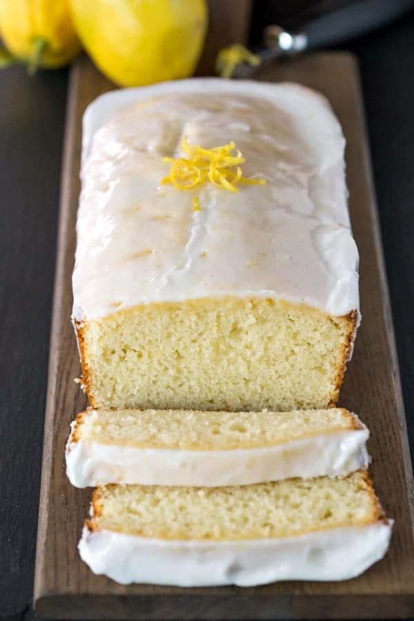 Iced lemon loaf of a wooden cutting board