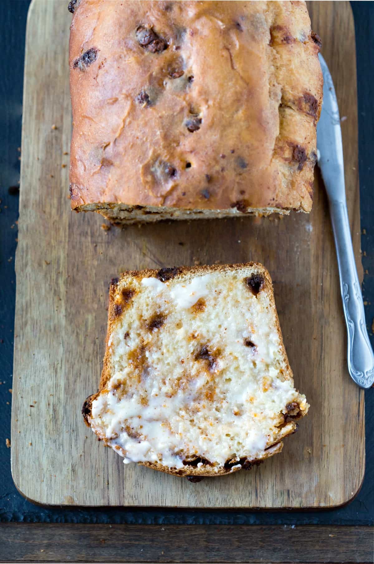 Slice of cinnamon chip bread on a wooden cutting board