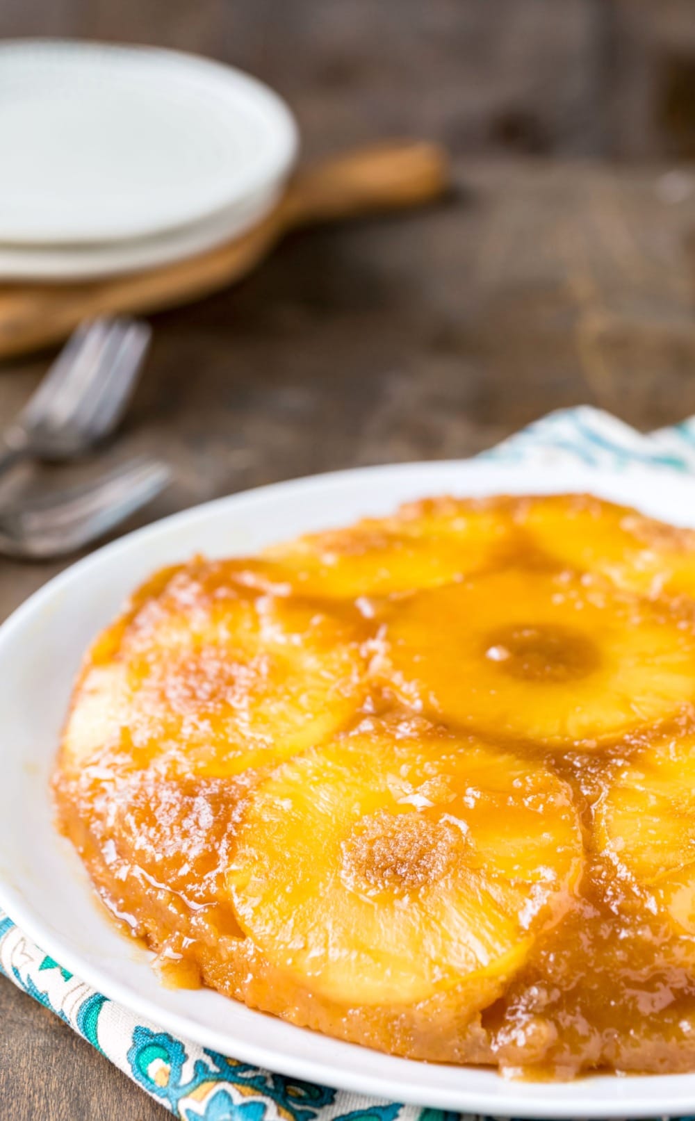 Pineapple Upside-Down Cake on a white platter next to two silver forks