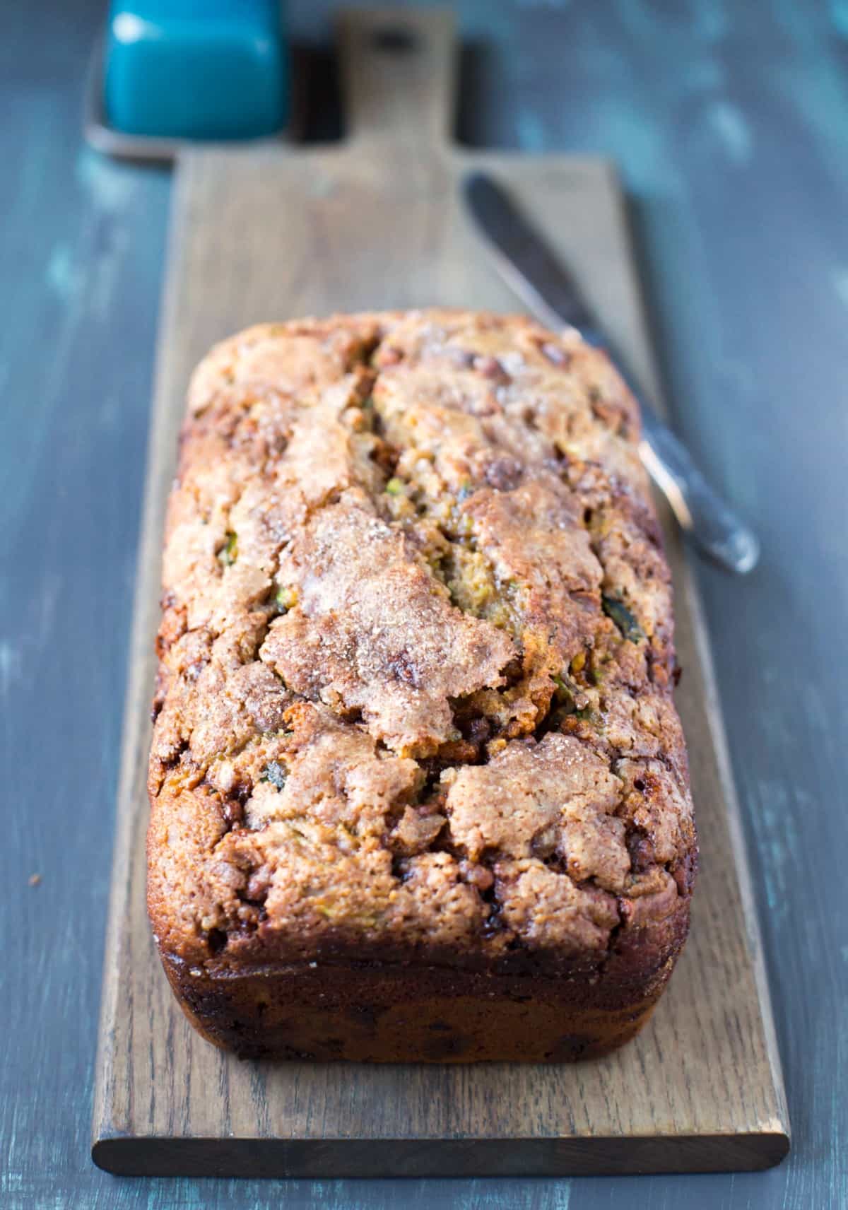 Loaf of Cinnamon Chip Whole Wheat Zucchini Bread on a wooden cutting board