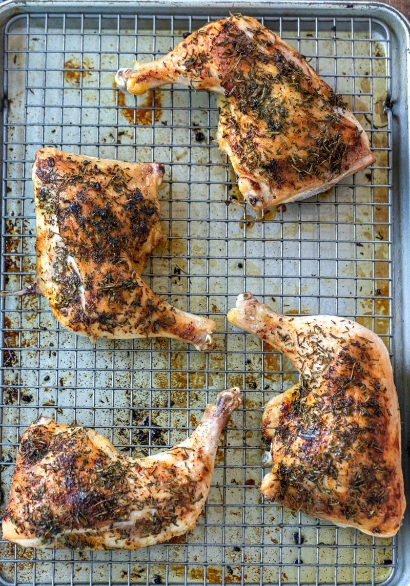 4 pieces of herb roasted chicken on a roasting pan