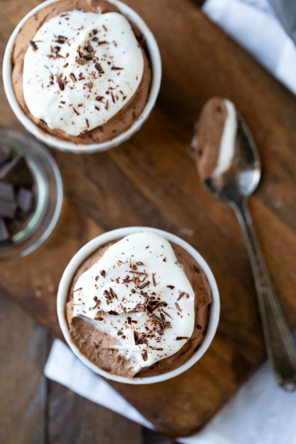 Finished chocolate mousse recipe in white dishes on a wooden cutting board