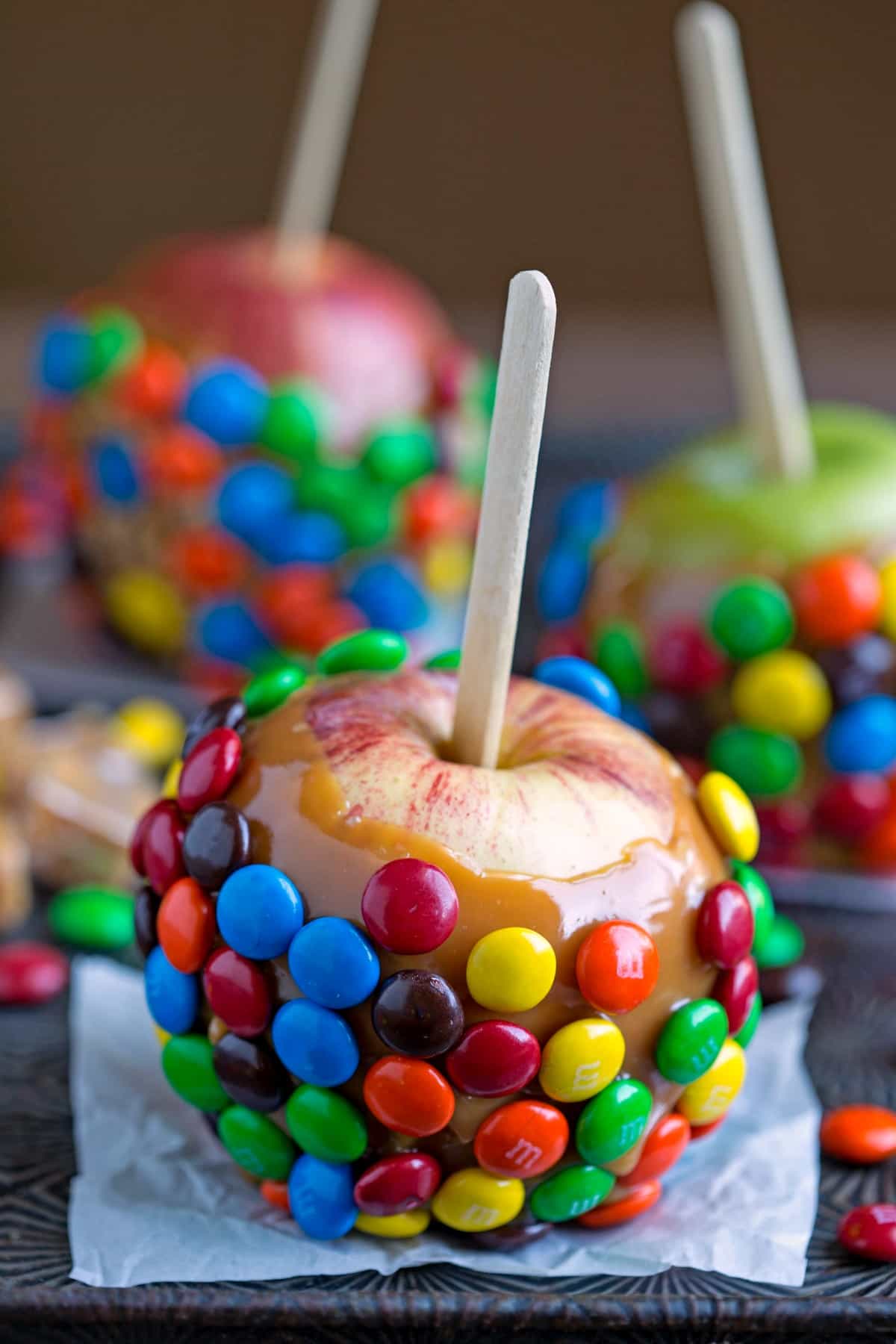 M&M Caramel Apples on a piece of white parchment paper. 