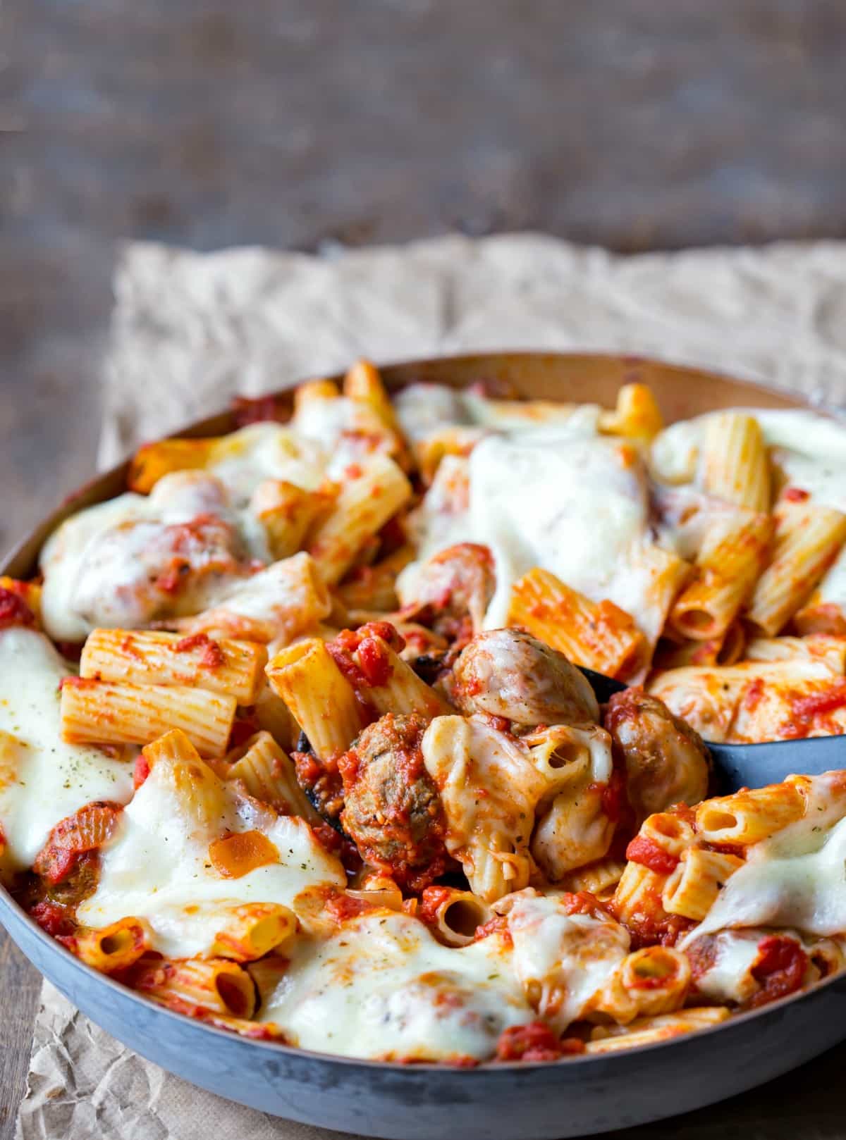 Skillet of meatball pasta on a piece of brown parchment paper