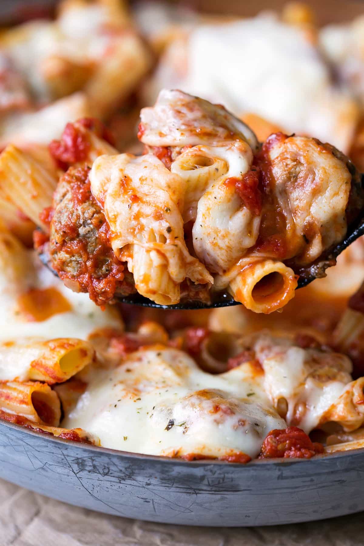 Scoop of skillet meatball pasta on a black spoon