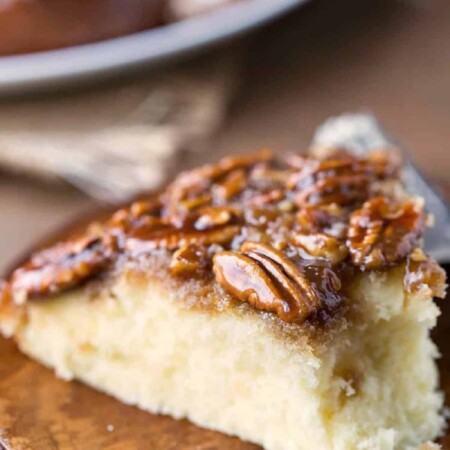 A slice of pecan pie upside down cake with a bite missing.