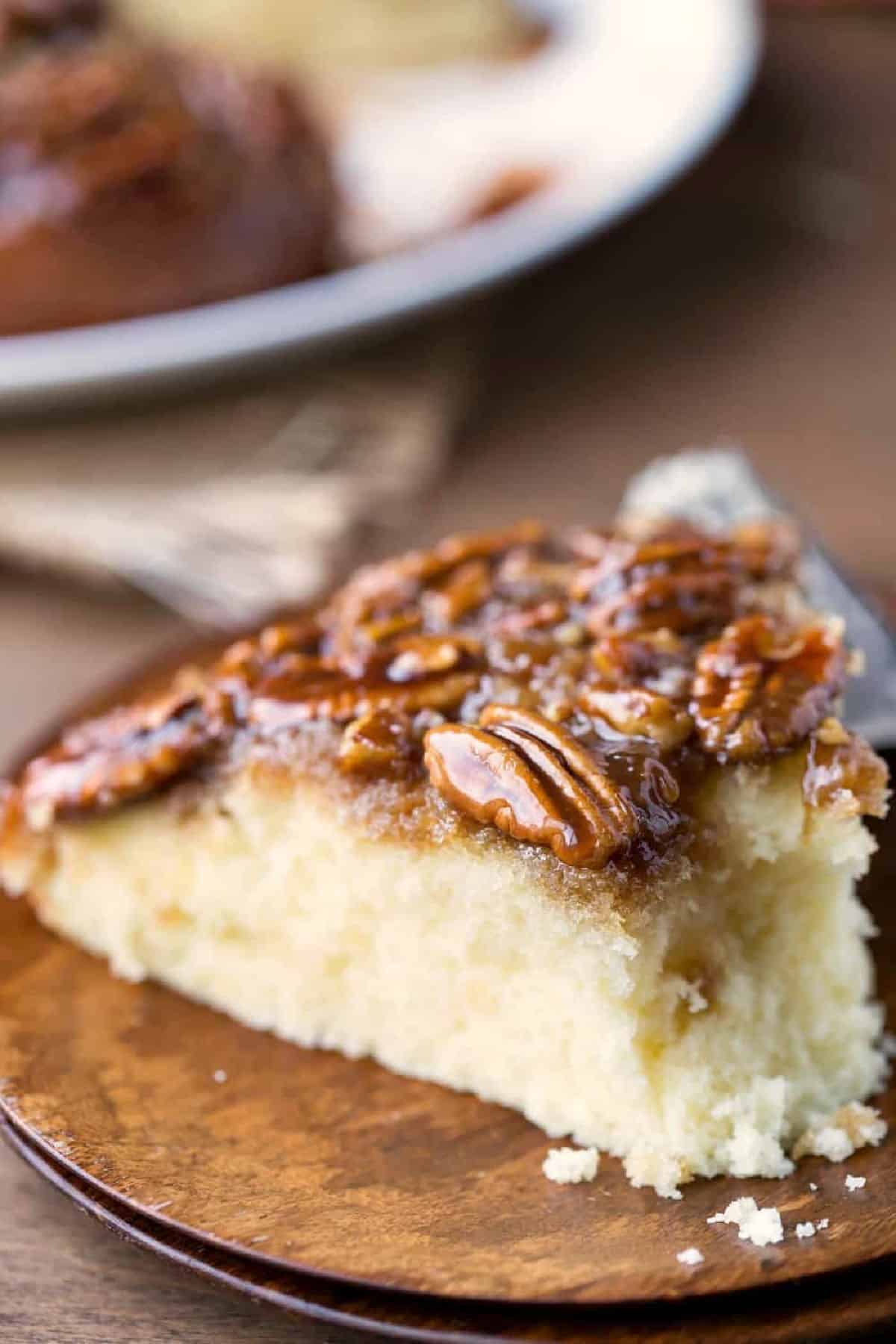 A slice of pecan pie upside down cake with a bite missing. 