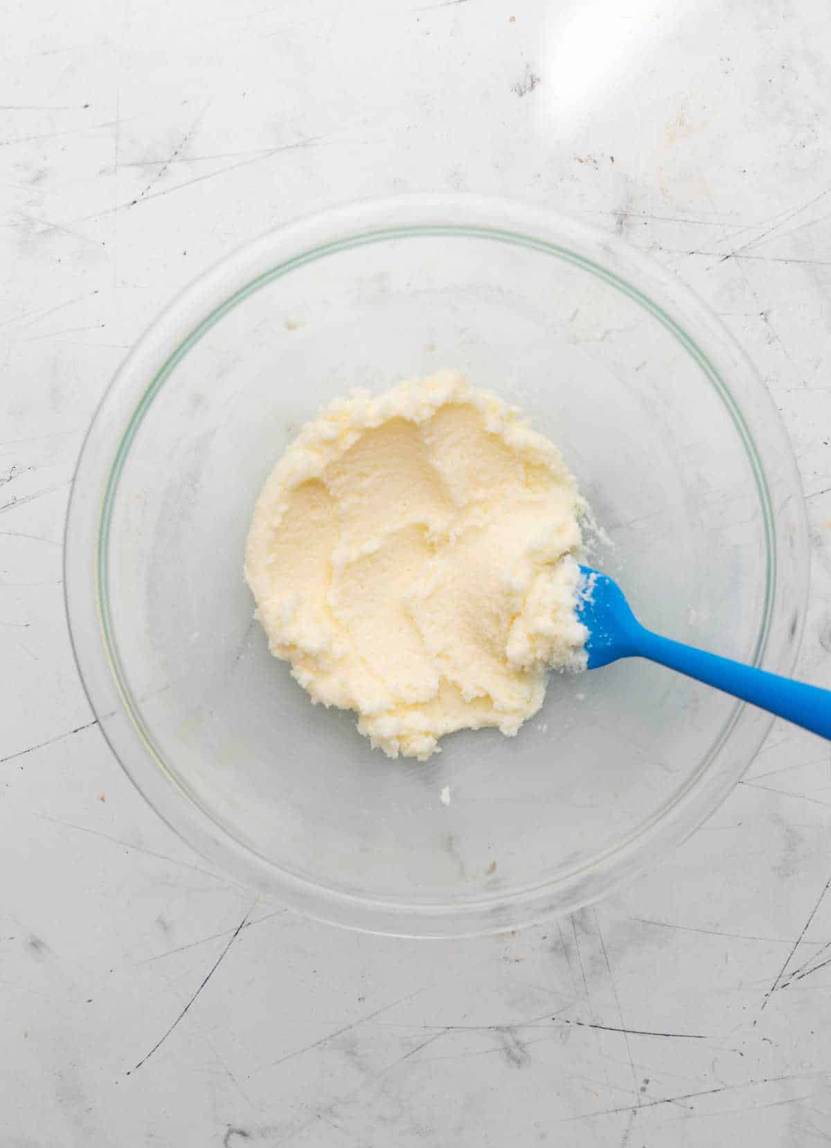 Creamed butter and sugar in a glass mixing bowl.
