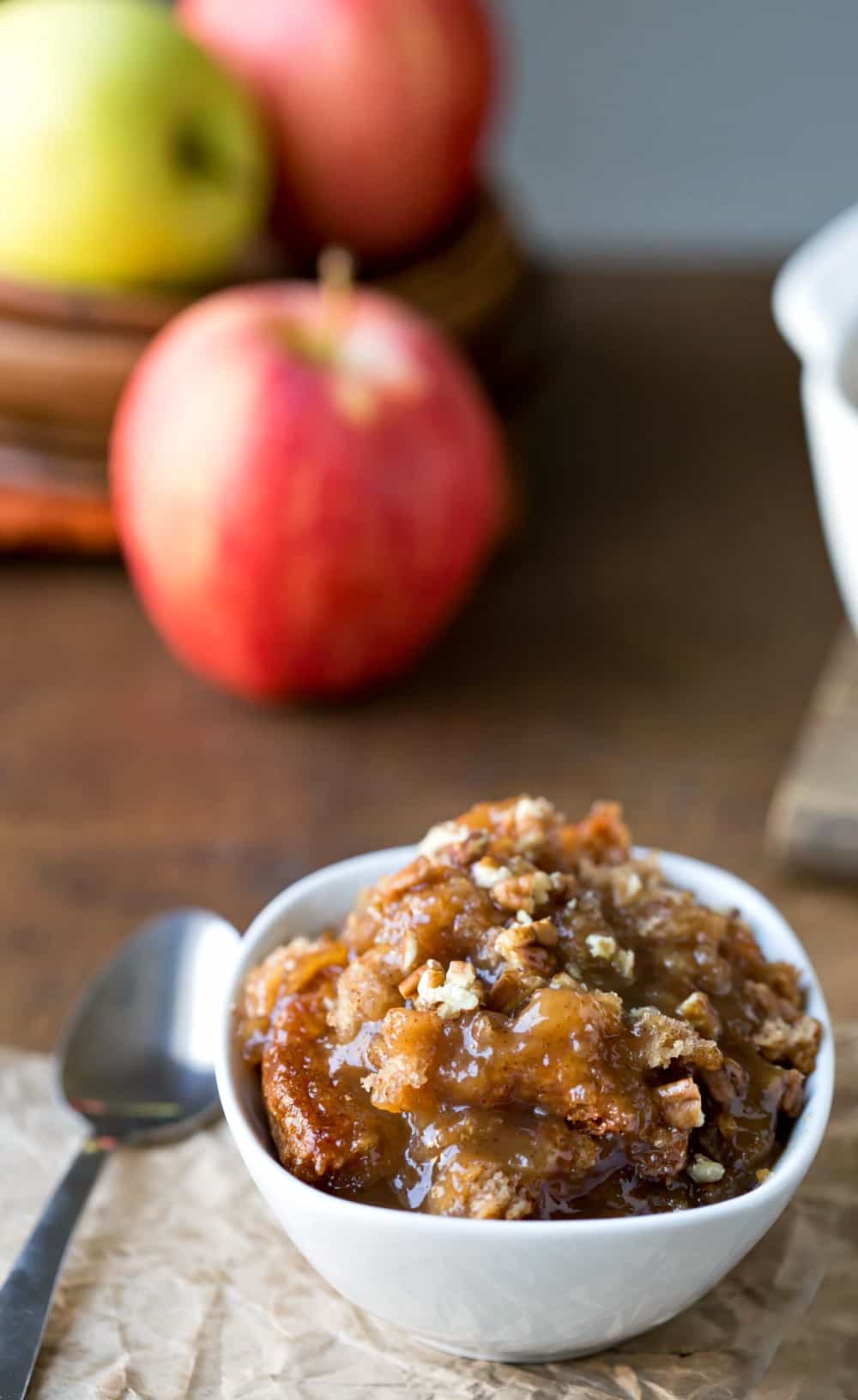 Caramel Apple Cobbler Cake Recipe next to apples and a silver spoon