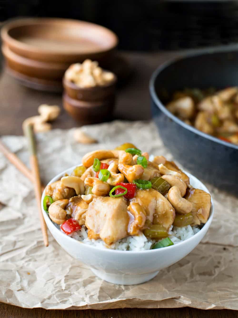 Bowl of cashew chicken topped with cashews and sliced green onions