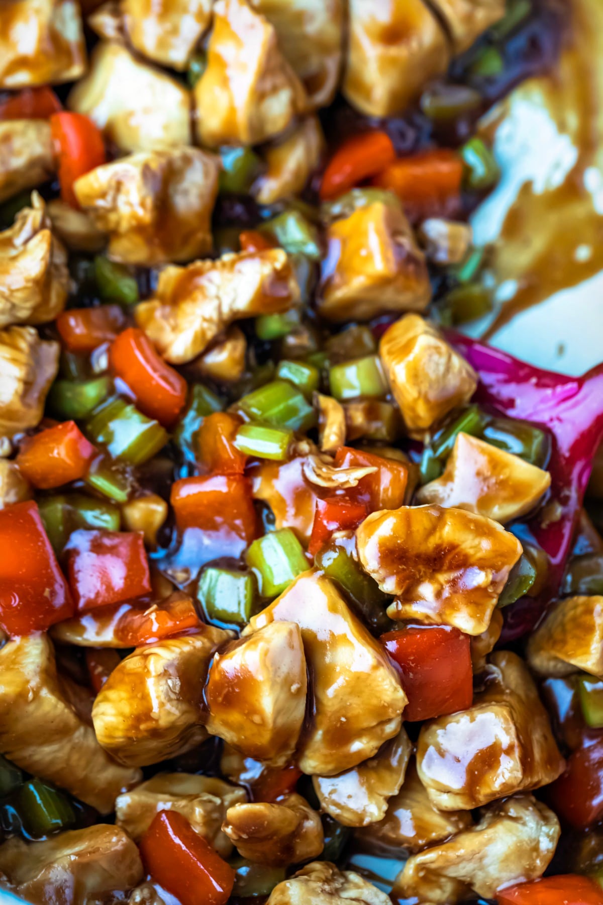 Spatula stirring cashew chicken in a skillet