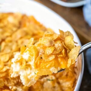 Silver spoon holding a scoop of funeral potatoes