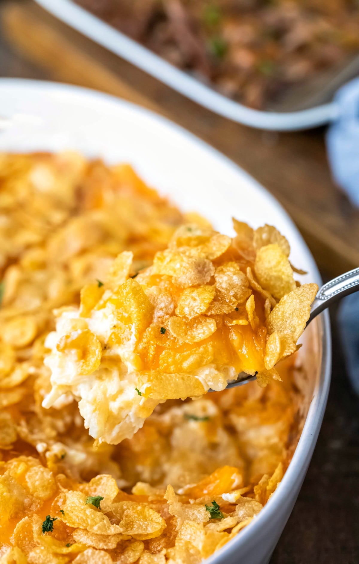 Silver spoon holding a scoop of funeral potatoes