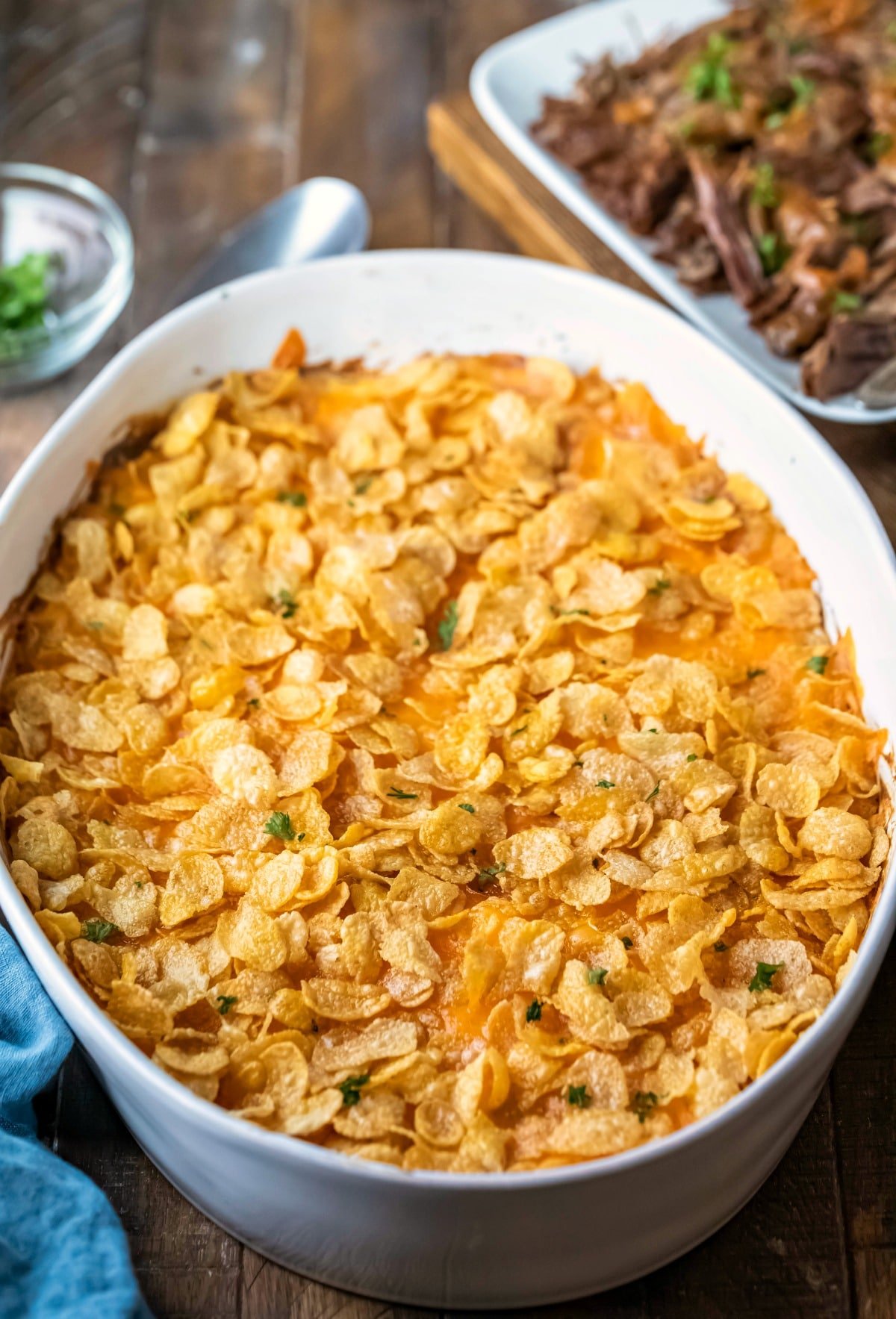 Funeral potatoes topped with cornflakes and parsley