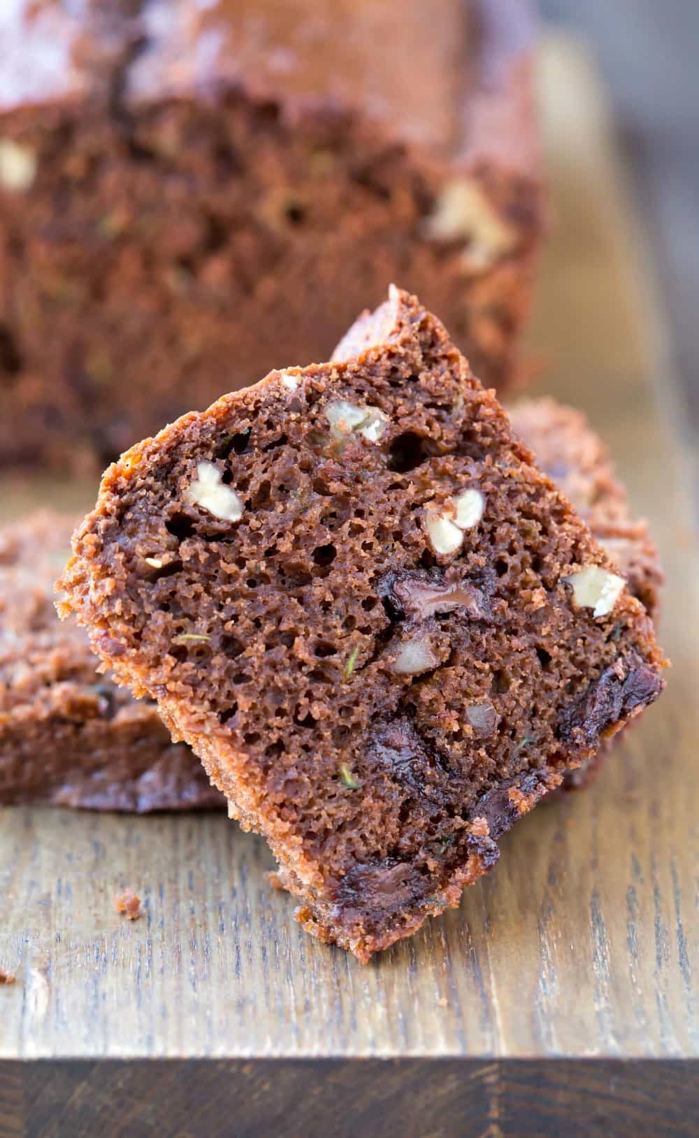 Slice of Chocolate Zucchini Bread on a wooden cutting board