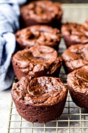 Muffin tin brownies on a wire cooling rack.
