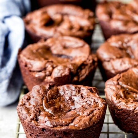 Muffin tin brownies on a wire cooling rack.