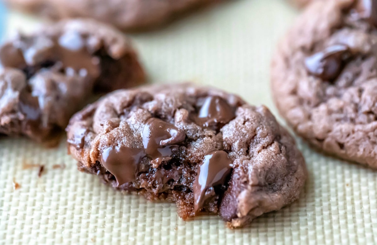 Half of a chocolate chocolate chip pudding cookie on a silicone baking mat