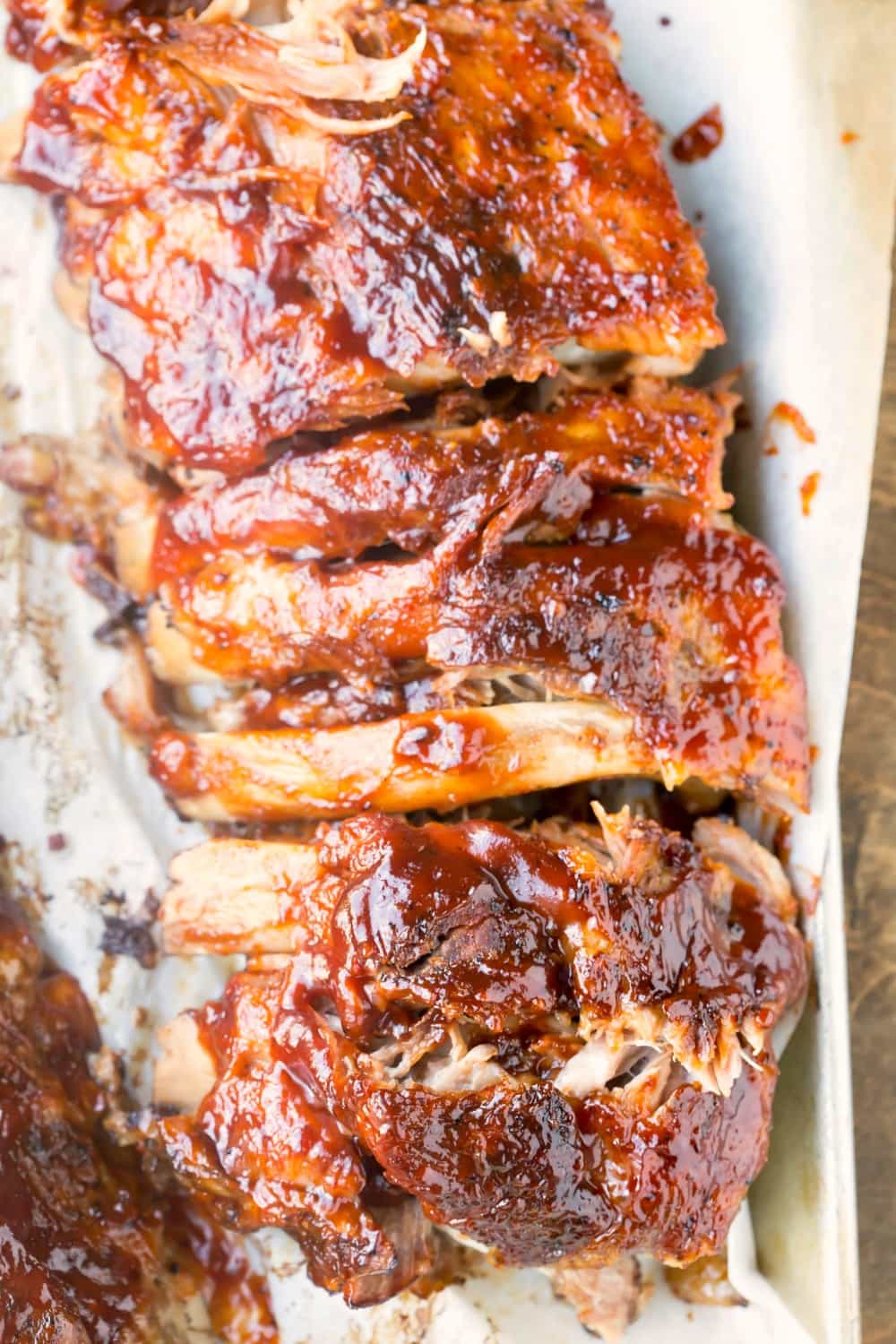 Slab of slow cooker ribs on a piece of white parchment paper.
