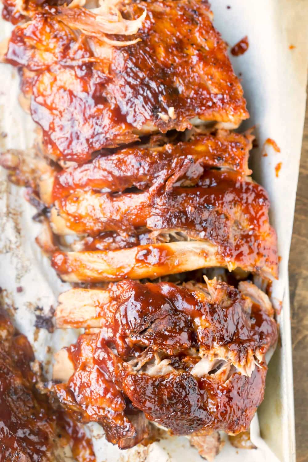 Slab of slow cooker ribs on a piece of white parchment paper. 