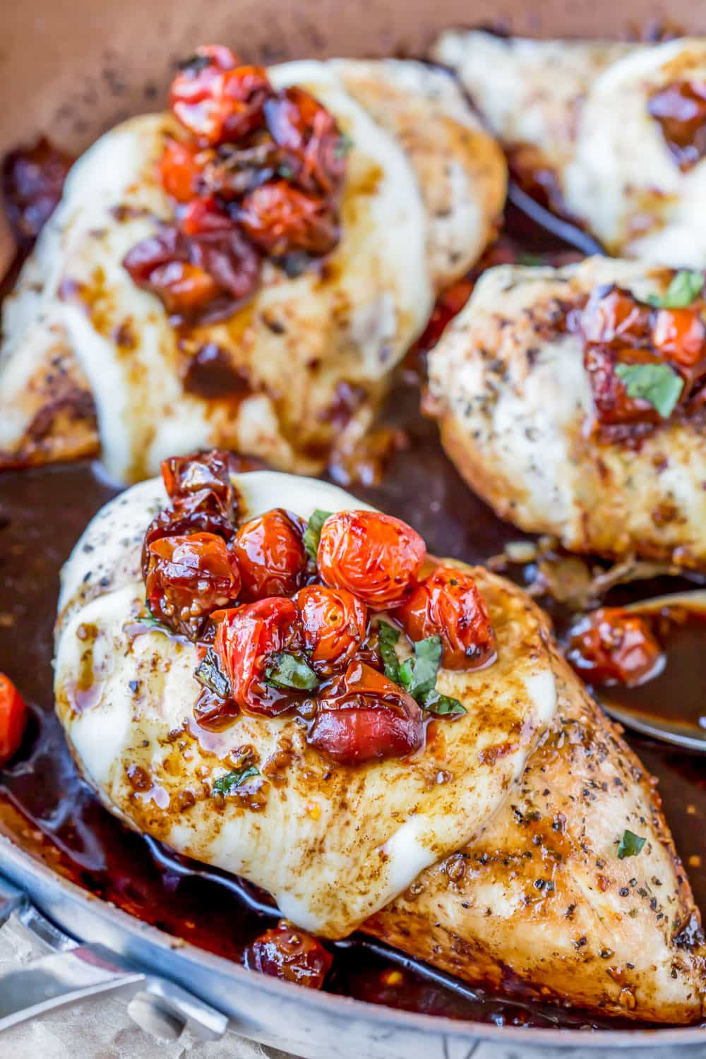 Caprese Chicken in a skillet with sauce