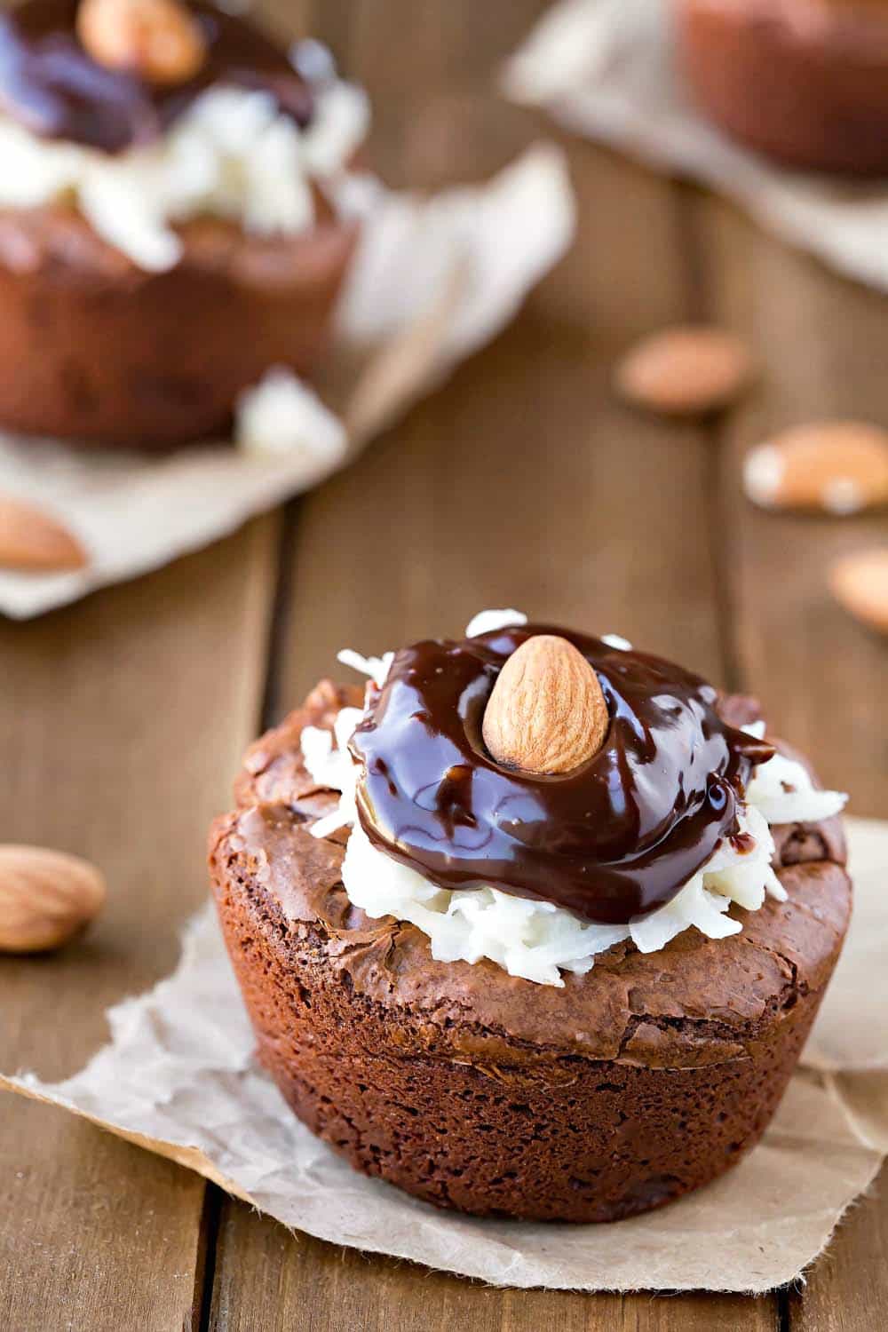 Almond Joy Brownie Bites on a piece of brown parchment on a wooden surfact