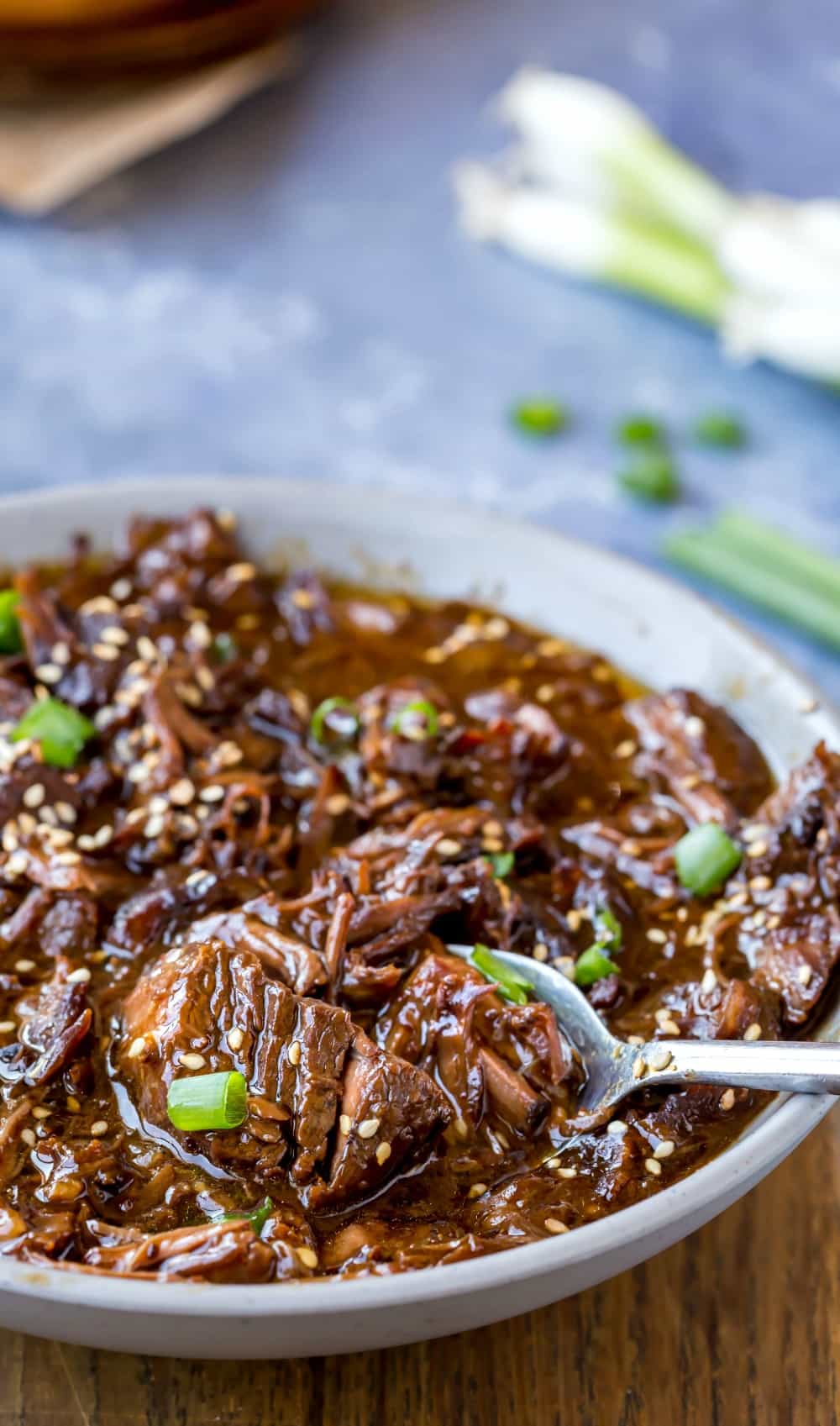 Scooping Slow Cooker Korean Beef with a silver spoon