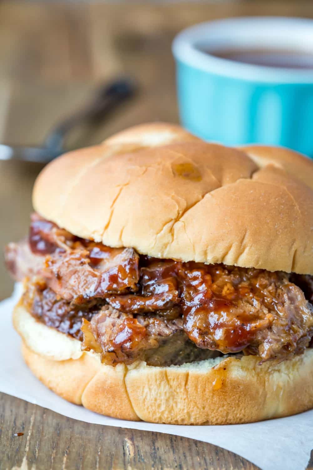 Slow Cooker Texas Brisket on a bun on a wooden cutting board