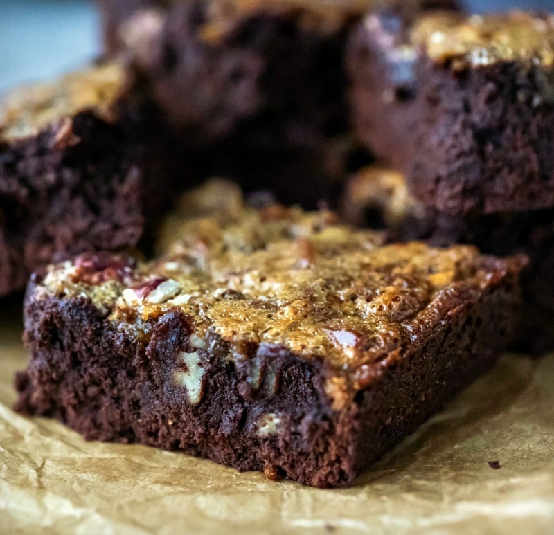 Close up photo of pecan pie brownie on brown parchment paper