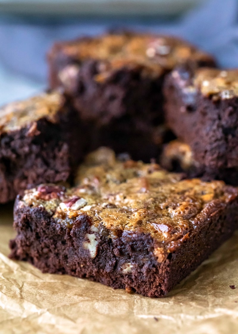 Stack of pecan pie brownies on a piece of brown parchment paper