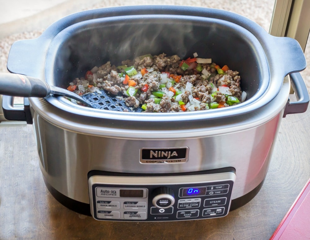 Vegetables and Italian sausage cooking in a slow cooker. 
