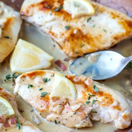 Lemon chicken breasts in a skillet.