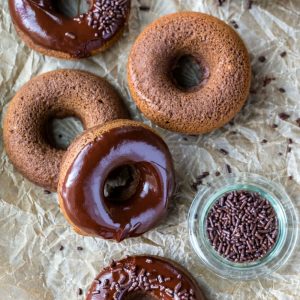 Chocolate baked donuts on brown parchment paper.