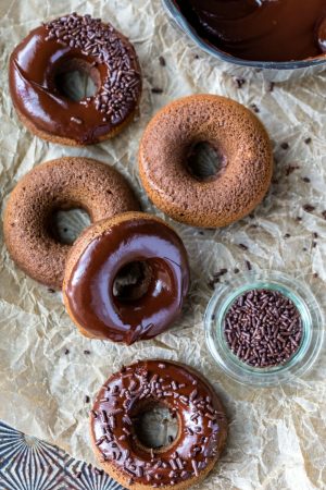 Chocolate baked donuts on brown parchment paper.